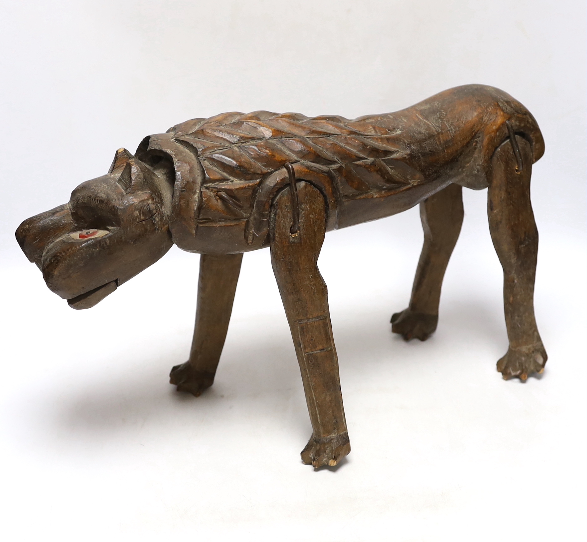 An primitive African articulated wood model of a lion, 41cm wide